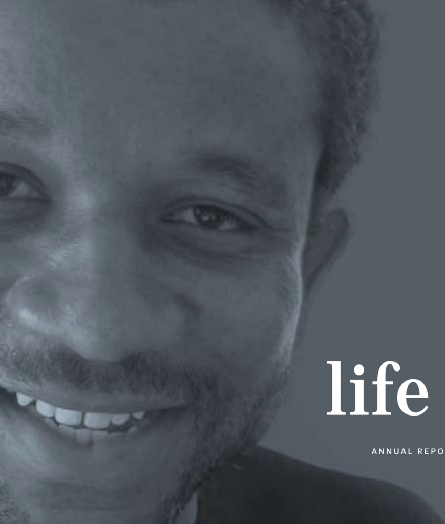 Close-up of a smiling man's face on the left side of the image; the word "life" and "ANNUAL REPORT" are visible on the gray background to the right.
