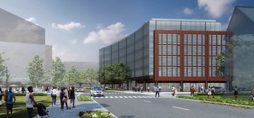 A modern office building with glass windows and a red-brown facade, surrounded by trees, people walking, and cars on a sunny day.