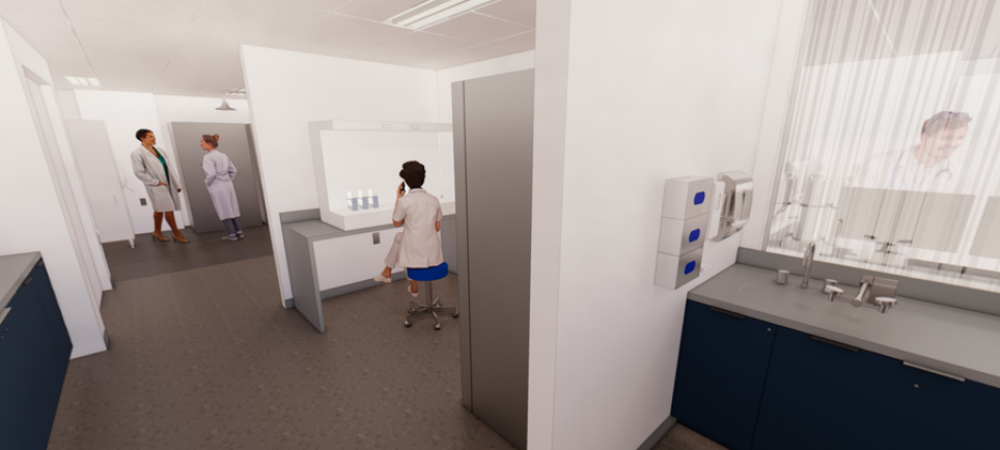 Three people in lab coats are in a clinical laboratory; one is seated at a workstation, while two are standing and talking near a doorway. Laboratory equipment is visible on counters.