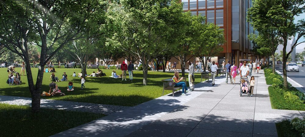 People walk on a sidewalk and gather on a grassy area with trees near a modern building, reflecting on the legacy of redlining on this sunny day.